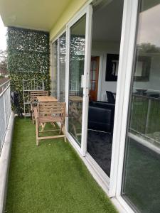 a patio with a table and a bench on a balcony at 3 Bedroom Apartment with Golf Course View in Newcastle upon Tyne