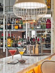 deux verres à martini assis sur un bar avec de l'alcool dans l'établissement H10 Duque de Loule, à Lisbonne