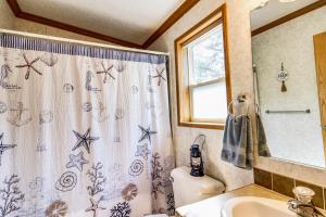 a bathroom with a shower curtain and a sink at Oak Harbor Walleye Camp in Baudette +18 photos