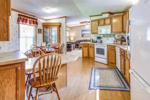 a kitchen with wooden cabinets and a table and chairs at Oak Harbor on Lake of the Woods & Rainy River in Baudette