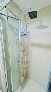 マニラにあるCity Views FAME Residencesのバスルーム(ガラスドア付きのシャワー付)