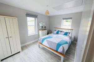 een slaapkamer met een bed en 2 ramen bij Terry Joe Cottages in Newry