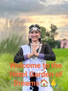 a woman in a field with text welcome to the hotel garden of dreams at Hotel Garden of Dreams in Sauraha