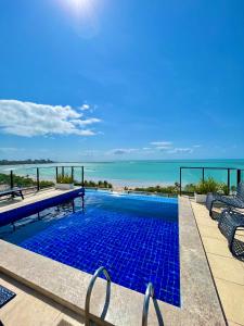 a swimming pool with a view of the ocean at Vistamar Hotel in Maceió