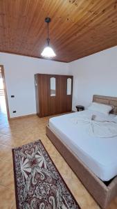 1 dormitorio con 1 cama grande y techo de madera en Appartamento vicino al centro storico en Shkodër