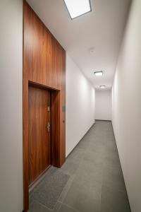 pasillo con puerta de madera y suelo de baldosa en Premium Apartament Centrum Garbary 45m2 Parking, en Bydgoszcz