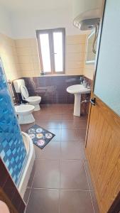 y baño con 2 aseos, bañera y lavamanos. en Appartamento vicino al centro storico en Shkodër