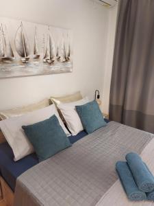 a bedroom with a bed with blue pillows on it at Antigonidon Square Luxury Apartment in Thessaloniki