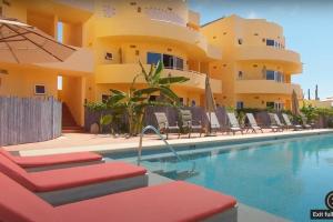 a hotel with a swimming pool in front of a building at 2B - Cerritos Beach Condo, Lrg Pool, Baja Sur in El Pescadero