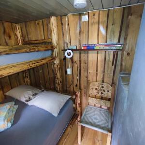 a bedroom with a bunk bed and a chair at Tiny Cozy House in Pärispea