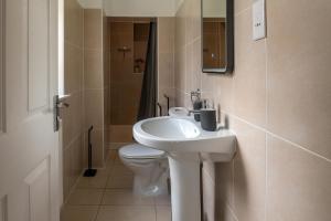 a bathroom with a white sink and a toilet at Number 3 in Trefriw +14 photos