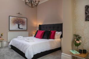 a bedroom with a large bed with pink pillows at Number 3 in Trefriw