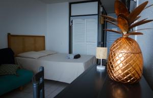 a bedroom with a bed and a pineapple on a table at Studio GAP in Le Diamant
