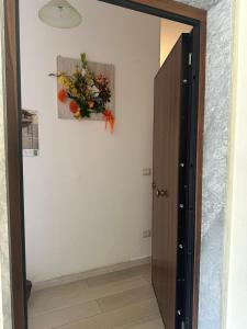 eine Tür zu einem Zimmer mit Blumenarrangement an der Wand in der Unterkunft La casa di Beatrice in Catanzaro Lido