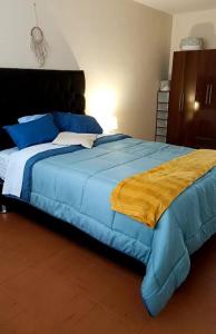 a bedroom with a blue bed with a yellow blanket at MINI DEPARTAMENTO independiente, privado y cómodo in Arequipa