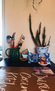 une table avec des ustensiles et un vase avec une plante dans l'établissement MINI DEPARTAMENTO independiente, privado y cómodo, à Arequipa
