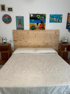 Schlafzimmer mit einem großen Bett mit einem Kopfteil aus Holz in der Unterkunft La casa di Beatrice in Catanzaro Lido