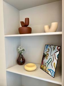 a shelf with a book and a plate and vase at Jack, 2 people, renovated stylish apartment in Athens