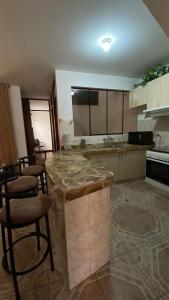 La Molina的住宿－Departamento La Molina，厨房配有柜台和一些椅子