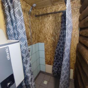 a bathroom with two shower curtains in a room at Tiny Cozy House in Pärispea
