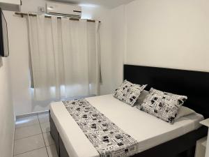 1 dormitorio con 1 cama con 2 almohadas y ventana en Bela Cintra Flat Service próximo aos principais pontos de turismo de São Paulo, en São Paulo