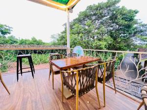 a wooden table and chairs on a deck at The Mayfield Resort, Vagator in Anjuna