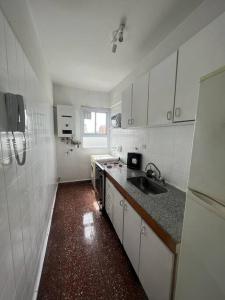 a white kitchen with a sink and a refrigerator at Luminoso dpto 3 ambientes - Barrio Chino - River - FLENI in Buenos Aires