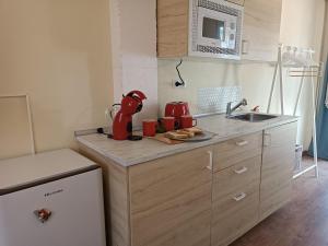 una cocina con fregadero y un aparato rojo en una encimera en SANTANDER-LIENCRES VILLA PERAL, en Liencres