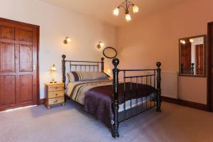 a bedroom with a bed and a dresser and a mirror at Super Spacious Country house pet/party friendly. in Newquay