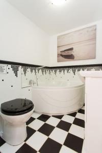 y baño con aseo, bañera y lavamanos. en Super Spacious Country house pet/party friendly., en Newquay