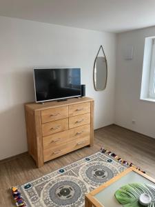 a living room with a flat screen tv on a dresser at AM Fleurystr, ALL NEW, komfortabel, ZENTRAL in Amberg!!! in Amberg