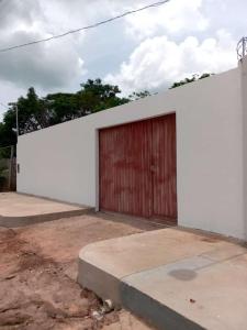 un bâtiment blanc avec une porte de garage rouge dans l'établissement CASA ALTER CARDOSO DA ROCHA, à Alter do Chão