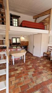 Puyloubier的住宿－Studio Au Pied De La Sainte Victoire，客厅配有桌子和双层床。