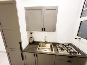 a small kitchen with a sink and a stove at Moods Holiday Homes in Al Ain