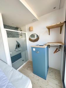 Cette petite chambre comprend une armoire bleue et un lit. dans l'établissement Les Voiles - Appart'hotel "Le Ouessant", à Carnac