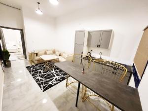 a kitchen and living room with a table and a couch at Moods Holiday Homes in Al Ain