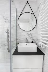 a white bathroom with a sink and a mirror at Zen Nest Tiny House in Şirnea