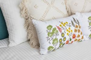希爾內亞的住宿－Zen Nest Tiny House，一张带白色枕头的床,床上有鲜花