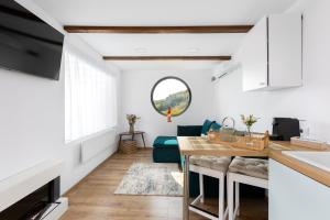 希爾內亞的住宿－Zen Nest Tiny House，厨房以及带蓝色沙发的客厅。