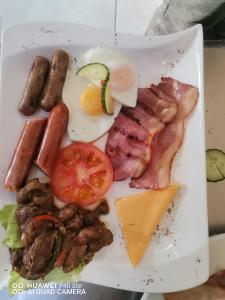 a plate of food with sausage meat and cheese at THE GALAXY FOREST LODGE in Manguzi