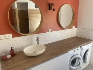 a bathroom with a sink and a washing machine at La Clé de Julian in Amiens