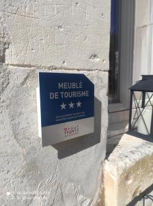una señal en el lado de un edificio que lee Meekle de torture en Le gîte "La belle époque" classé 3 Etoiles, en Tanlay