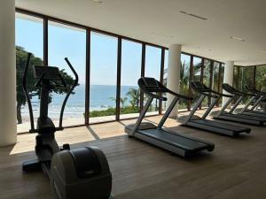a gym with a row of treadmills and the ocean at Departamento Pacific Luxury Punta Mita, Beachfront in Higuera Blanca