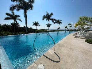 a swimming pool with a hose in the water at Departamento Pacific Luxury Punta Mita, Beachfront in Higuera Blanca