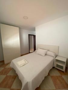 una camera con un grande letto bianco e un armadio di Asís 20.2 a Medina Sidonia