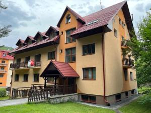 ein großes Gebäude mit vielen Fenstern und einem Dach in der Unterkunft Apartmán KINALI Horní Lipová in Ober Lindewiese