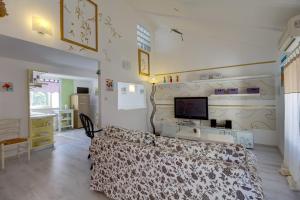 1 dormitorio con 1 cama y TV en la pared en Apartments Mandarina en Mali Lošinj