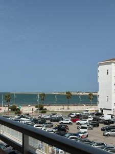 un aparcamiento en la playa con coches aparcados en Apartamento en Valdelagrana en primera línea de playa, en El Puerto de Santa María