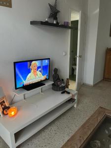 sala de estar con TV en una mesa blanca en Apartamento en Valdelagrana en primera línea de playa, en El Puerto de Santa María