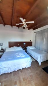 a bedroom with two beds and a ceiling fan at Hotel Andino - Adults Only in Cafayate